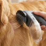Main utilisant une brosse aspirante électrique grise sur le pelage d'un chien à poils longs pour retirer les poils morts et les collecter dans le réservoir transparent.
