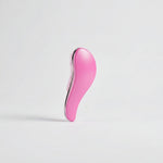 Brosse de toilettage ergonomique rose avec picots souples, conçue pour démêler le poil des chiens et chats sans tirer.