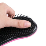 Gros plan montrant un pouce pressant les picots noirs d'une brosse ergonomique pour illustrer leur souplesse et leur capacité à démêler le poil en douceur sans irriter la peau.
