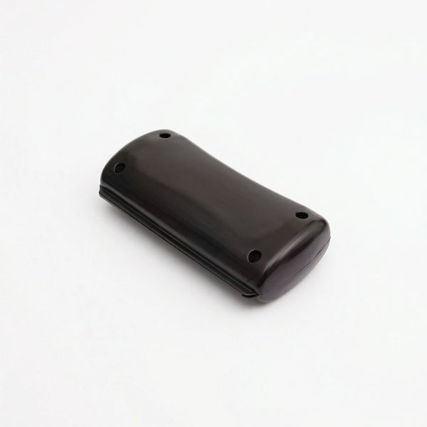 Brosse pour animaux de couleur noir avec tête ergonomique et dents métalliques incurvées, conçue pour retirer le sous-poil mort sans couper le pelage, sur fond blanc.