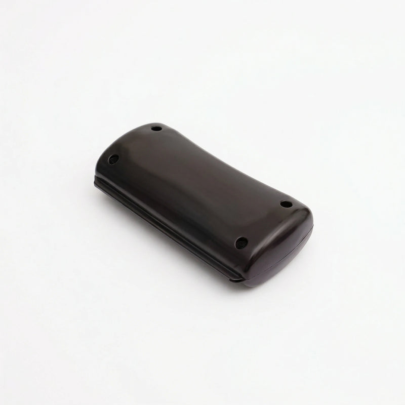 Brosse pour animaux de couleur noir avec tête ergonomique et dents métalliques incurvées, conçue pour retirer le sous-poil mort sans couper le pelage, sur fond blanc.
