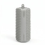 Brosse rectangulaire en silicone gris avec picots souples sur toutes les faces et attache de suspension, conçue pour le brossage des animaux et le retrait des poils.