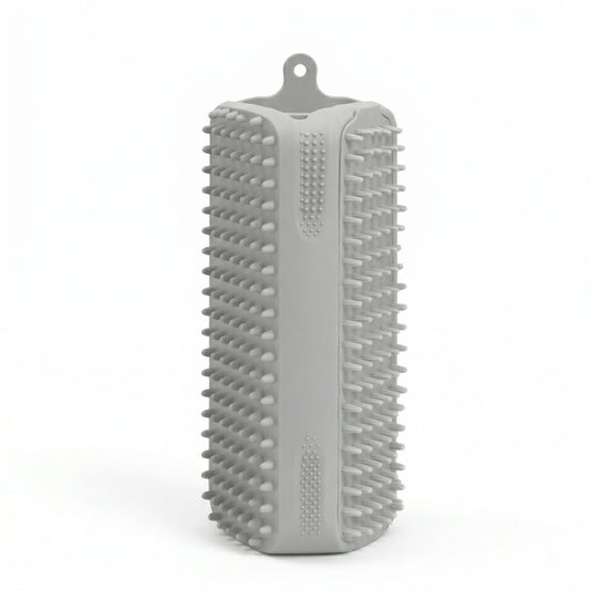 Brosse rectangulaire en silicone gris avec picots souples sur toutes les faces et attache de suspension, conçue pour le brossage des animaux et le retrait des poils.