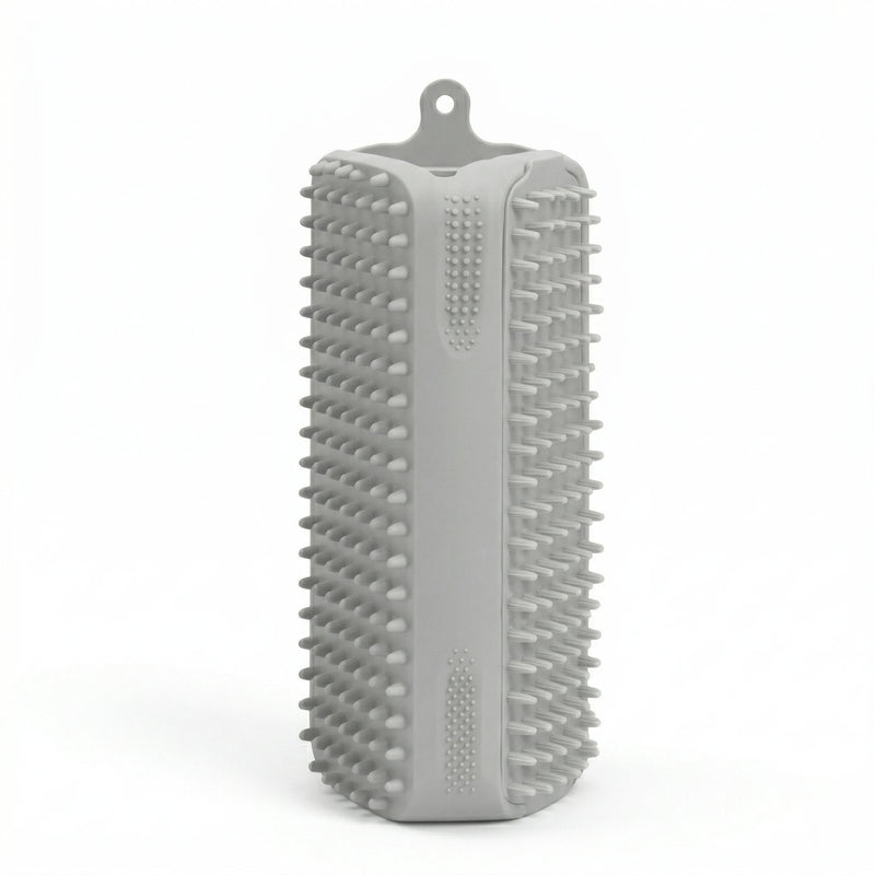 Brosse rectangulaire en silicone gris avec picots souples sur toutes les faces et attache de suspension, conçue pour le brossage des animaux et le retrait des poils.