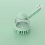 Main pressant une brosse de bain en silicone blanc pour faire sortir du shampoing sur le pelage mouillé d'un Golden Retriever, éclaboussures d'eau, fond blanc.