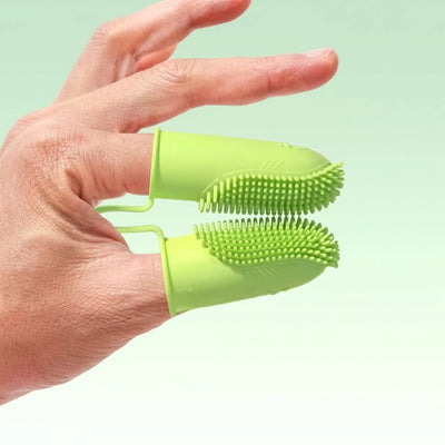 Brosse à dents double doigt en silicone vert tenue à la main pour nettoyage dentaire animal
