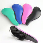 Présentation de la collection de brosses démêlantes pour animaux en vert, bleu, rose et noir, montrant le design ergonomique de la coque et les picots souples noirs.